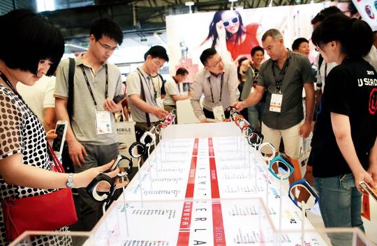 7 月15 日,观众在“世界移动大会·上海”暨上海国际信息消费节上试戴智能手环